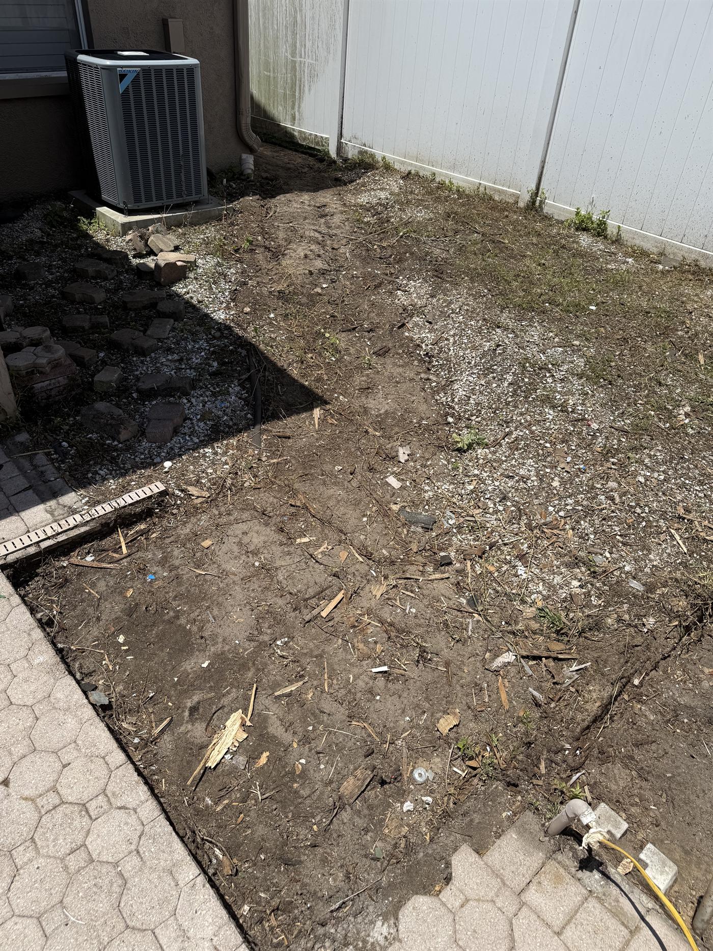 Bare side yard before cleanup and landscape installation.